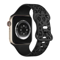 Alternate text: "Stylish smartwatch with a gold case, black display, and a distinctive black sports band featuring a cut-out design."